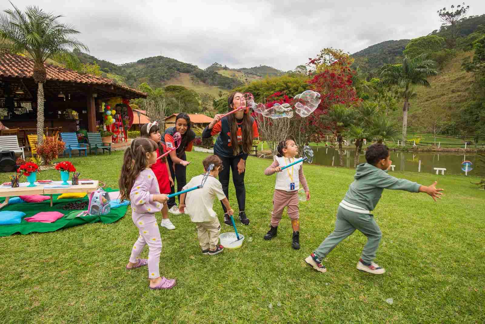 Crianças brincando com bolhas de sabão no jardim